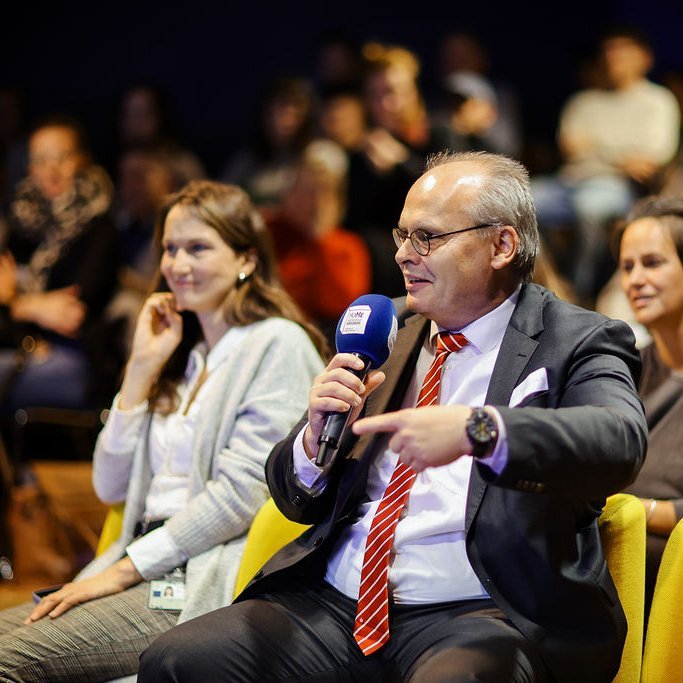Eine Person aus dem Publikum stellt eine Frage.